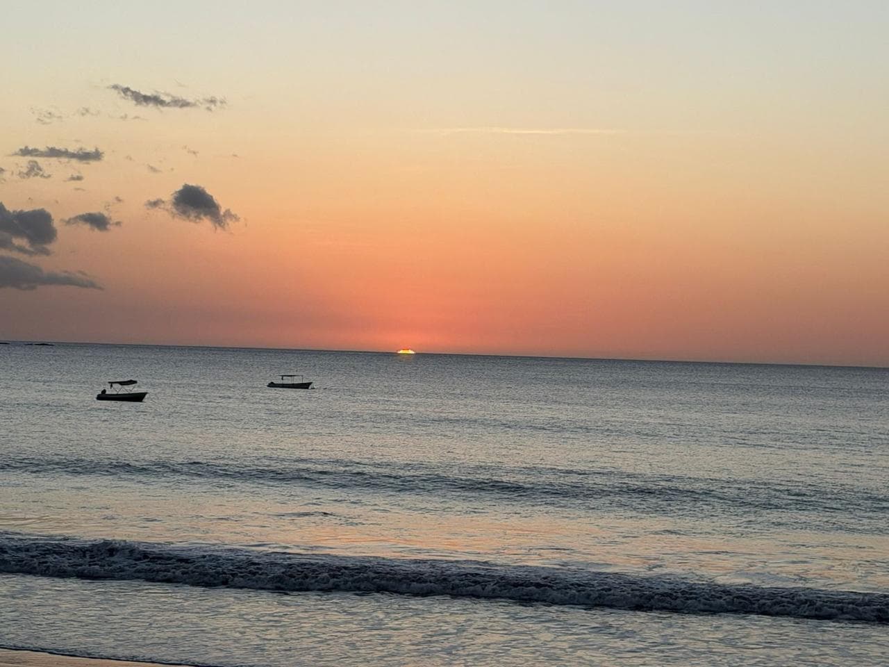 Mar en calma con botes al atardecer